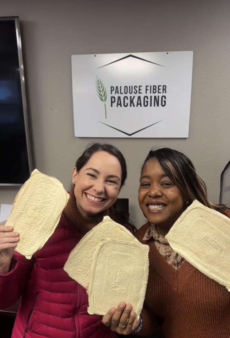 Erin and Vanessa holding molded fiber samples at Palouse Fiber Packaging